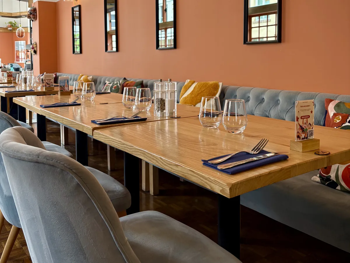 Grande tablée dressée dans la salle de L’Osteria